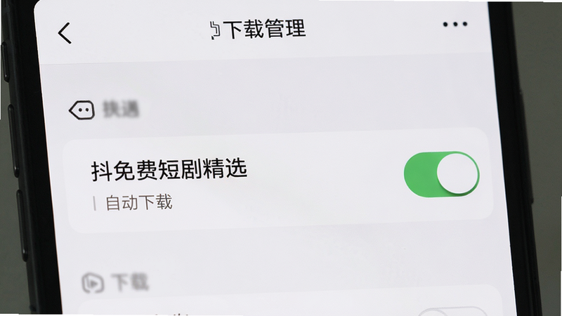 展示手机设置中的下载管理界面,主体为“抖免费短剧精选”APP的开关选项,布局简洁,风格现代,细节展示关闭状态,画质清晰,干净,文字标注“自动下载”