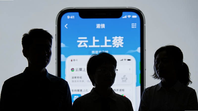 主体为三个人物剪影站在手机屏幕前,屏幕显示“云上上蔡”APP界面,布局为前景人物背影与背景屏幕结合,排版具有层次感,风格为写实摄影风,细节显示手机屏幕发光照亮人物面部,画质高清,干净,无多余元素