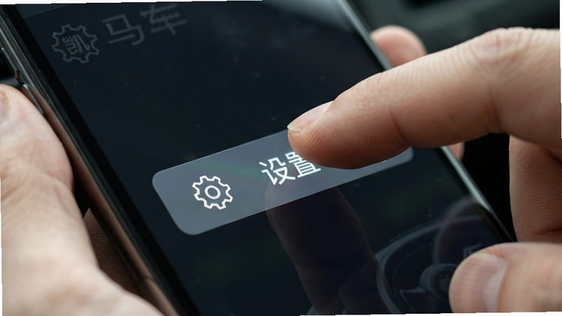 凯马车管家APP操作教程示意图,主体为手指点击手机屏幕的特写,布局聚焦于“设置”按钮,风格写实,光影自然,细节清晰,高分辨率,无干扰元素