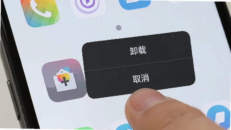 手机桌面上有一个应用图标被手指点击,上方弹出“卸载”和“取消”两个选项,背景是整洁的手机桌面,图标色彩鲜艳,操作直观,风格扁平、清晰、无多余装饰