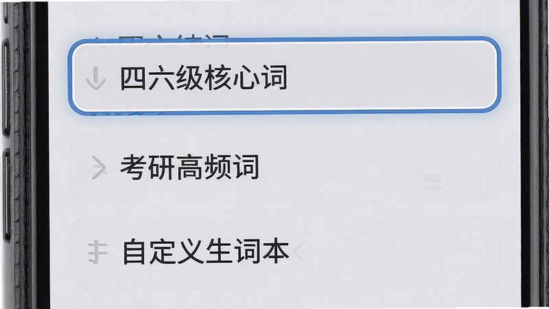 主体为手机界面,显示词库选择列表,列表项包括“四六级核心词”、“考研高频词”、“自定义生词本”,选中项有高亮边框,背景为浅灰色,风格商务简洁,字体清晰易读,布局规整,细节处有轻微的圆角处理,画质清晰,干净利落