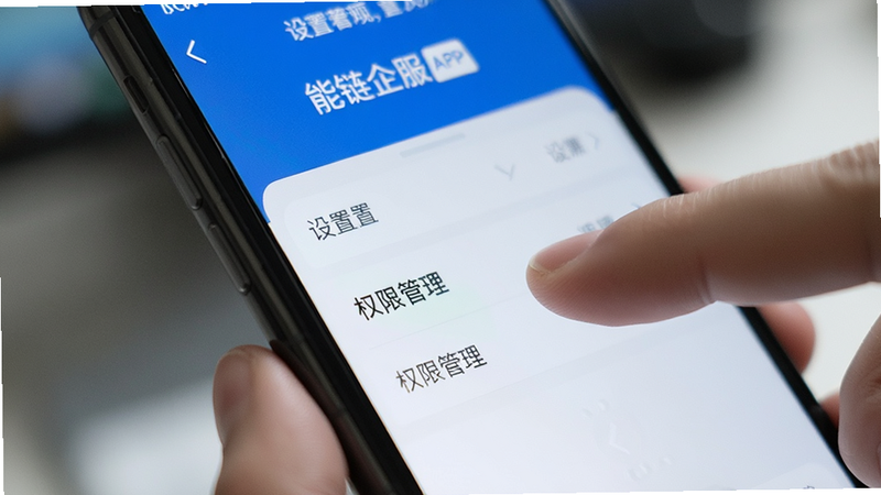 手机屏幕上显示能链企服APP的设置页面,手指正在点击“权限管理”选项,背景虚化,突出操作细节,风格清晰直观,无多余装饰,高清特写