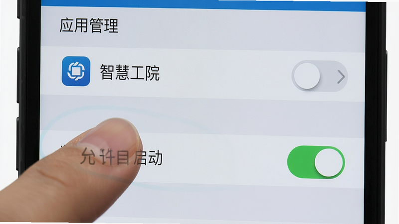 一张手机设置界面的示意图,手指点击“应用管理”中的“智慧工院”,下方显示“允许自启动”的开关处于开启状态,界面清晰,高亮显示关键选项,风格写实,细节清晰,画质高清,无干扰元素