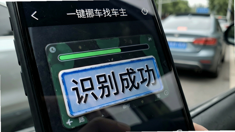 主体为手机摄像头扫描车牌的特写镜头,屏幕界面显示识别进度条和“识别成功”字样,背景虚化显示真实车辆场景,布局聚焦屏幕操作区域,排版紧凑,风格为写实科技风,细节展现车牌反光与屏幕光影互动,画质锐利,干净,无杂乱背景,文字“一键挪车找车主”在屏幕顶部清晰可见。