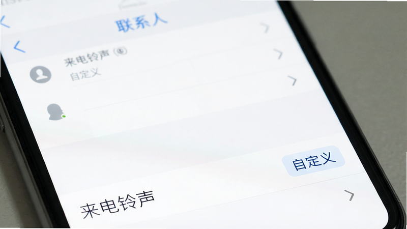 手机界面展示“联系人”应用详情页,底部显示“来电铃声”选项,旁边有“自定义”标签,界面简洁,白色背景,蓝色文字,高清,无多余元素