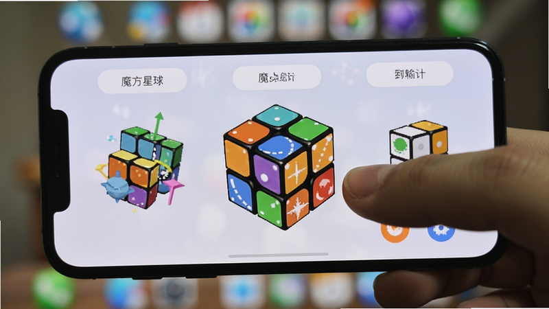 主体为“魔方星球”APP在手机屏幕上的实际运行效果图,布局展示完整的还原界面,背景为模糊的桌面壁纸,排版自然真实,风格生活化,细节处有手指操作的痕迹,画质真实,无水印,无多余元素