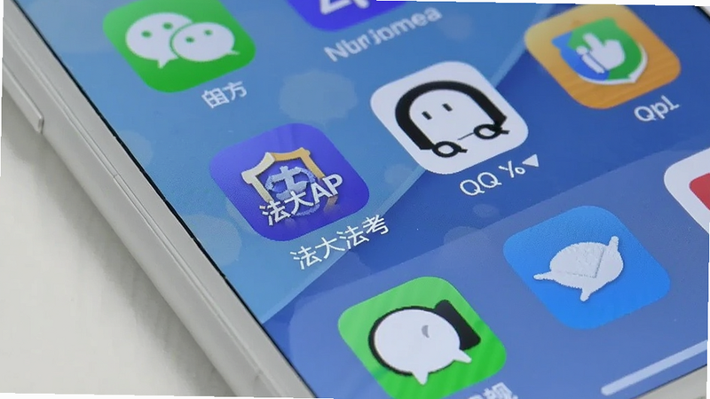 手机桌面截图,显示法大法考APP图标,旁边有微信、QQ等常用APP图标,背景为简洁的壁纸,手机边框为白色,光线明亮,真实拍摄风格,突出APP的日常使用场景