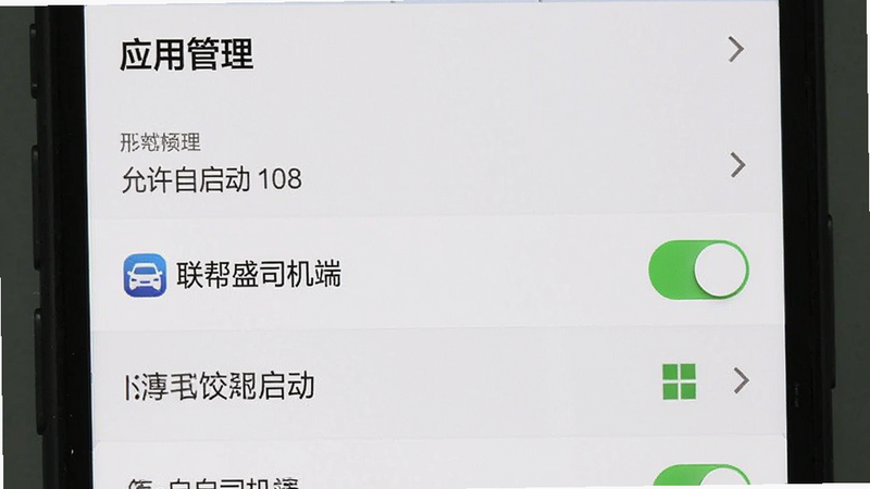 主体为手机设置界面,显示“应用管理”列表,其中“联帮盛司机端”高亮显示,布局为垂直列表,排版紧凑,系统风格,细节包含“允许自启动”开关已开启,画质清晰,干净,无多余元素