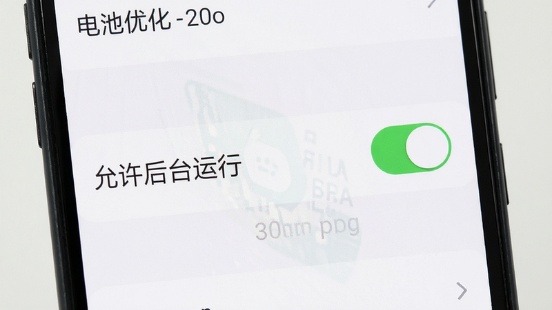 主体为手机设置界面特写,布局清晰,排版垂直,风格扁平化,细节展示电池优化设置开关,文字显示“允许后台运行”,画质清晰,干净,无多余元素