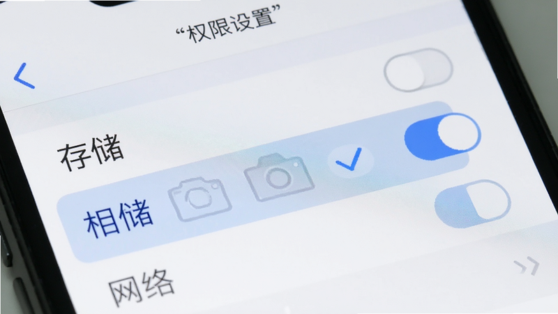 手机屏幕显示权限设置页面,列表中有“存储”、“相机”、“网络”等选项,其中“存储”选项被勾选,界面风格简洁,白色背景,灰色文字,细节处有开关按钮,高清画质,干净无多余元素,文字加引号“权限设置”