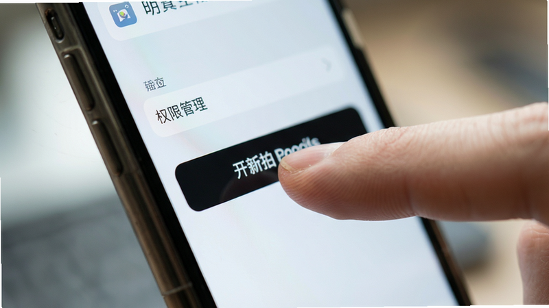 手机侧面特写,手指正在点击“开新拍”的设置按钮,界面显示权限管理选项,背景模糊,焦点集中在手指和屏幕,风格清晰写实,光线明亮,细节清晰,画质高清