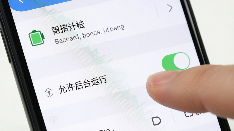 手机设置界面特写,显示电池管理和后台运行选项,手指正在点击“允许后台运行”开关,界面清晰,文字可读,模拟真实操作场景,教程风格,光线明亮,无杂乱背景,高清晰度