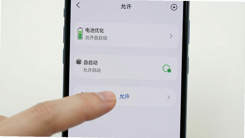 主体为手机设置界面,显示“电池优化”和“自启动”选项,手指正在点击“允许”,风格简洁,浅色背景,高清画质,无多余元素,文字清晰标注“允许自启动”