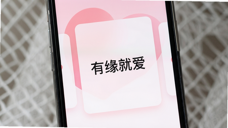 主体为手机屏幕特写,显示有缘就爱APP界面,布局为居中卡片式设计,排版简洁清晰,风格为现代简约风,细节包含柔和的粉色与白色渐变背景,画质高清,干净,无多余元素,屏幕中央有“有缘就爱”字样