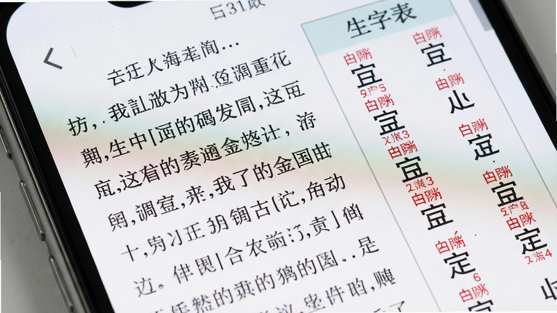 主体为手机屏幕特写,显示语文课本内页,左侧为课文正文,右侧为生字表,文字清晰锐利,注音红色醒目,排版严谨,风格写实,细节丰富,画质超清,干净无噪点