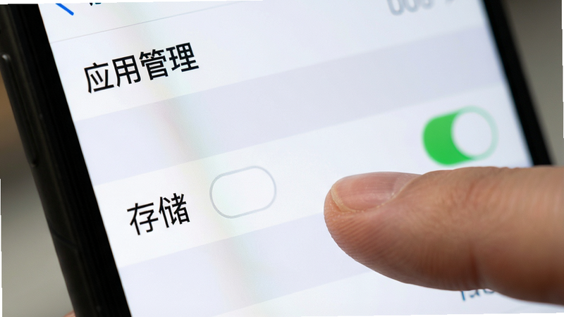 展示手机设置界面中“应用管理”选项的特写,手指正在点击“存储”权限开关,背景模糊,突出操作焦点,风格简洁明了,细节清晰,画质高,无多余图标