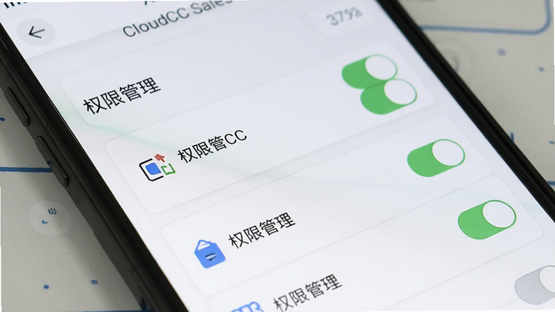 主体为智能手机特写,屏幕显示CloudCC Sales设置页面,包含权限开关列表,布局垂直排列,风格简洁明了,细节包含滑块开关、图标标识,文字标注