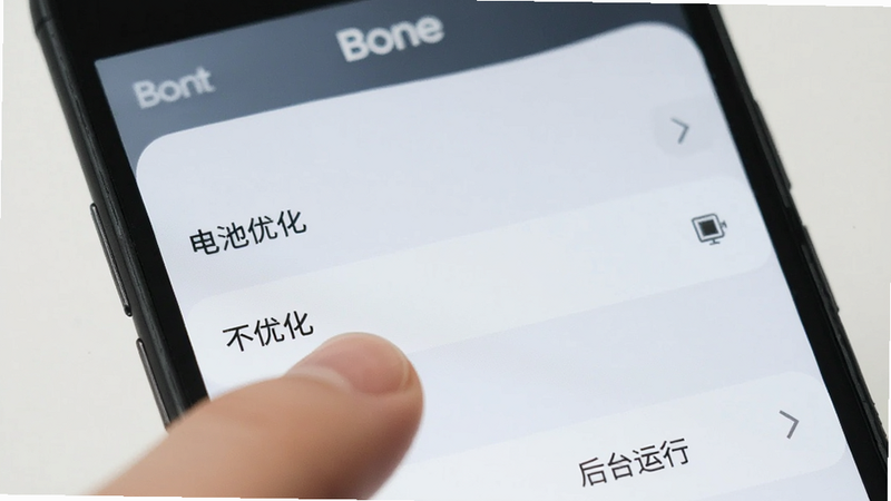 主体为手机设置界面,显示“电池优化”选项,手指点击“不优化”,布局简洁,风格扁平化,细节处有手机品牌Logo模糊处理,画质清晰,干净,文字显示“后台运行”