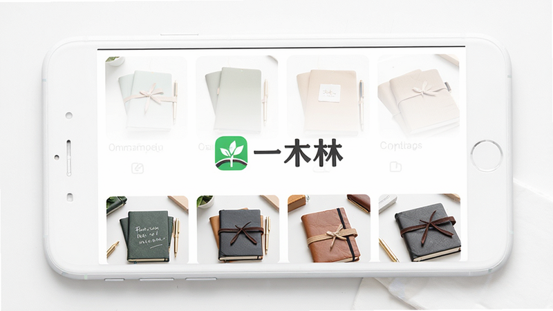 一木林App主界面展示,主体为白色背景的手机屏幕,屏幕中央显示“一木林”Logo及精选文具商品网格,布局整齐,排版清晰,风格简约现代,细节处体现文具质感,画质高清,干净,无多余元素