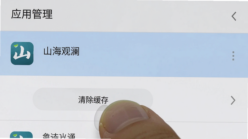 手机设置界面截图,显示“应用管理”列表,其中“山海观澜”应用被高亮选中,下方显示“清除缓存”按钮被手指点击的特写,界面整洁,色调为标准的安卓系统灰白色,高清,无水印