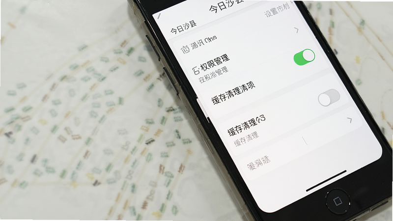 主体为手机屏幕显示“今日沙县”设置界面,布局展示权限管理与缓存清理选项,排版清晰,风格极简白底黑字,细节包含开关按钮状态,画质清晰,无多余元素