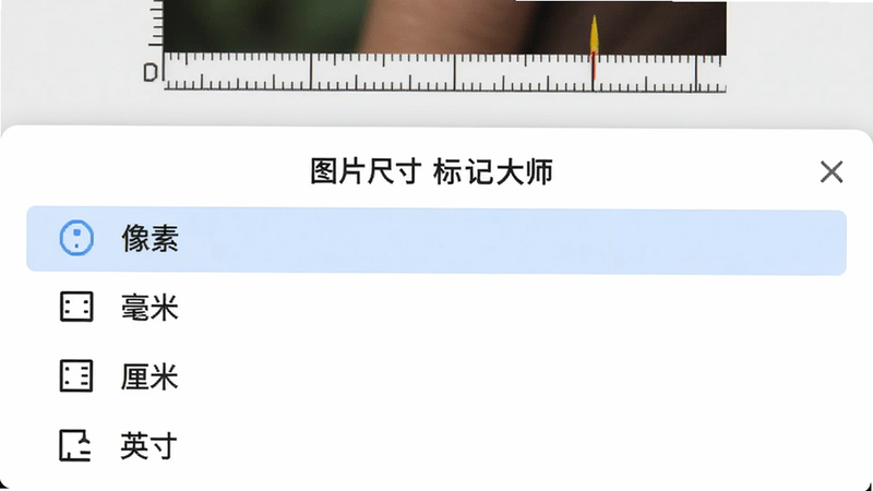 展示“图片尺寸标记大师”的单位切换功能界面,主体为屏幕下半部分的设置面板。布局为列表式排列,清晰列出“像素”、“毫米”、“厘米”、“英寸”四个选项,其中“像素”被高亮选中,背景呈淡蓝色。上方隐约可见正在测量的图片局部。整体排版整齐,图标与文字对齐,风格简洁明快,色彩搭配舒适,细节清晰,高清渲染。