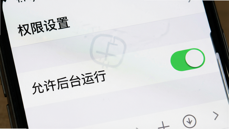 主体为手机设置界面的截图,布局聚焦在权限管理页面,中央高亮显示“允许后台运行”选项,排版清晰,风格为系统UI真实还原,细节显示开关按钮处于开启状态,画质清晰,干净无多余元素,文字显示